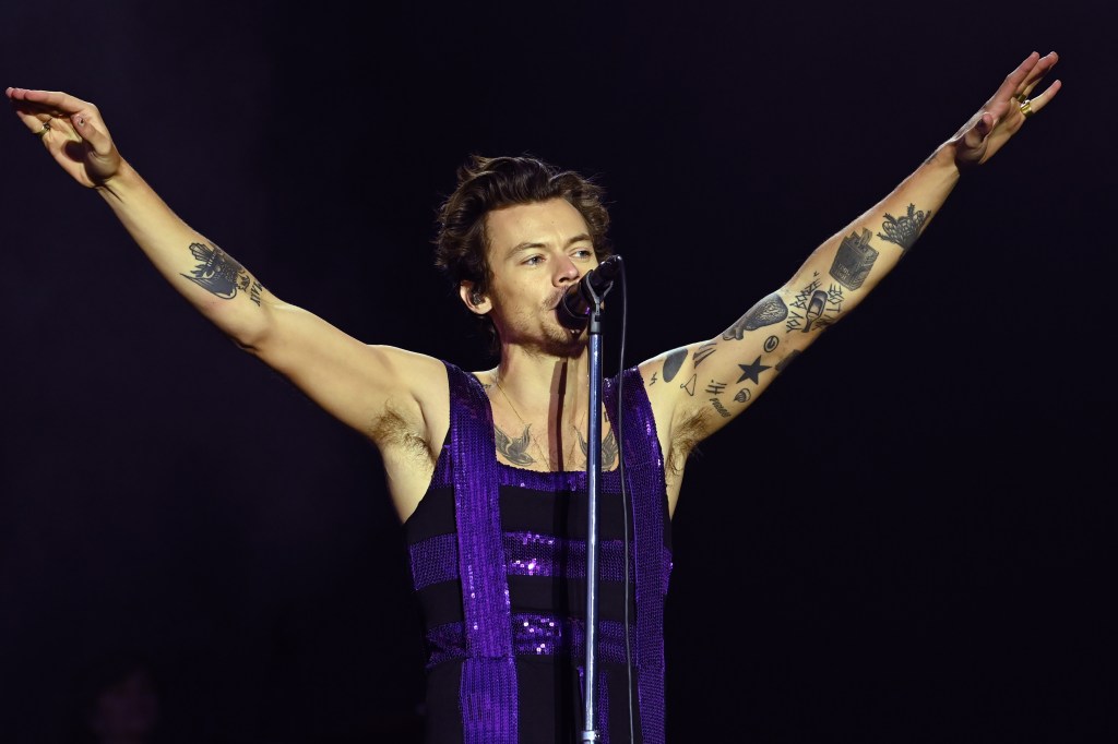 Harry Styles actuando con un mono de lentejuelas morado