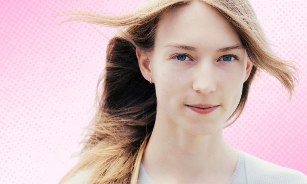 A trans woman superimposed on a pink gradient background.