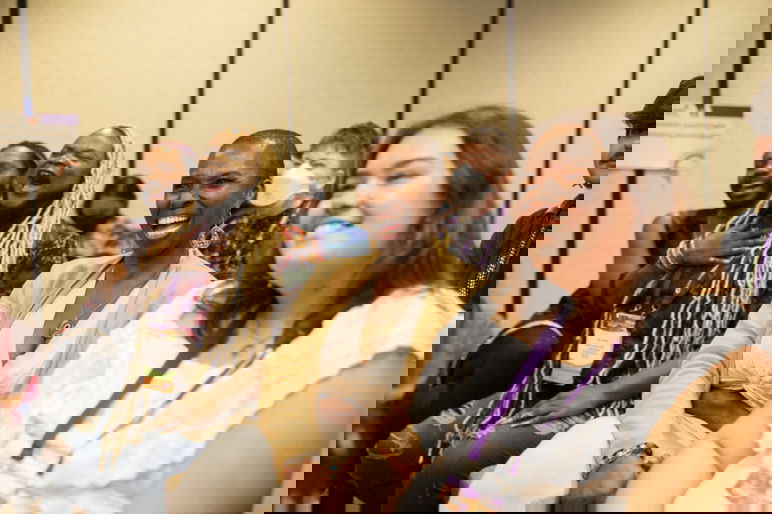 Los participantes sonríen durante una presentación en la conferencia Creando Cambio 2024.