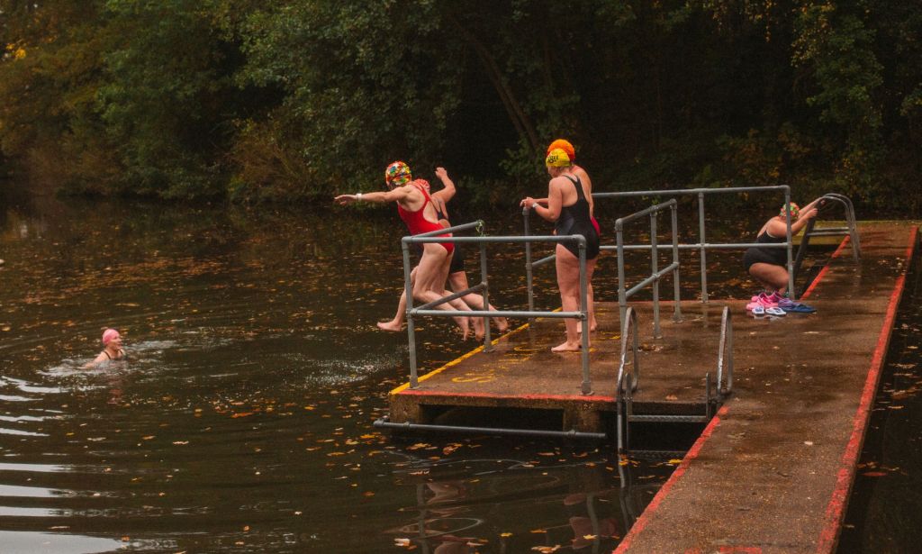 Nadadores saltando al estanque Hampstead Heath Ladies Pond.