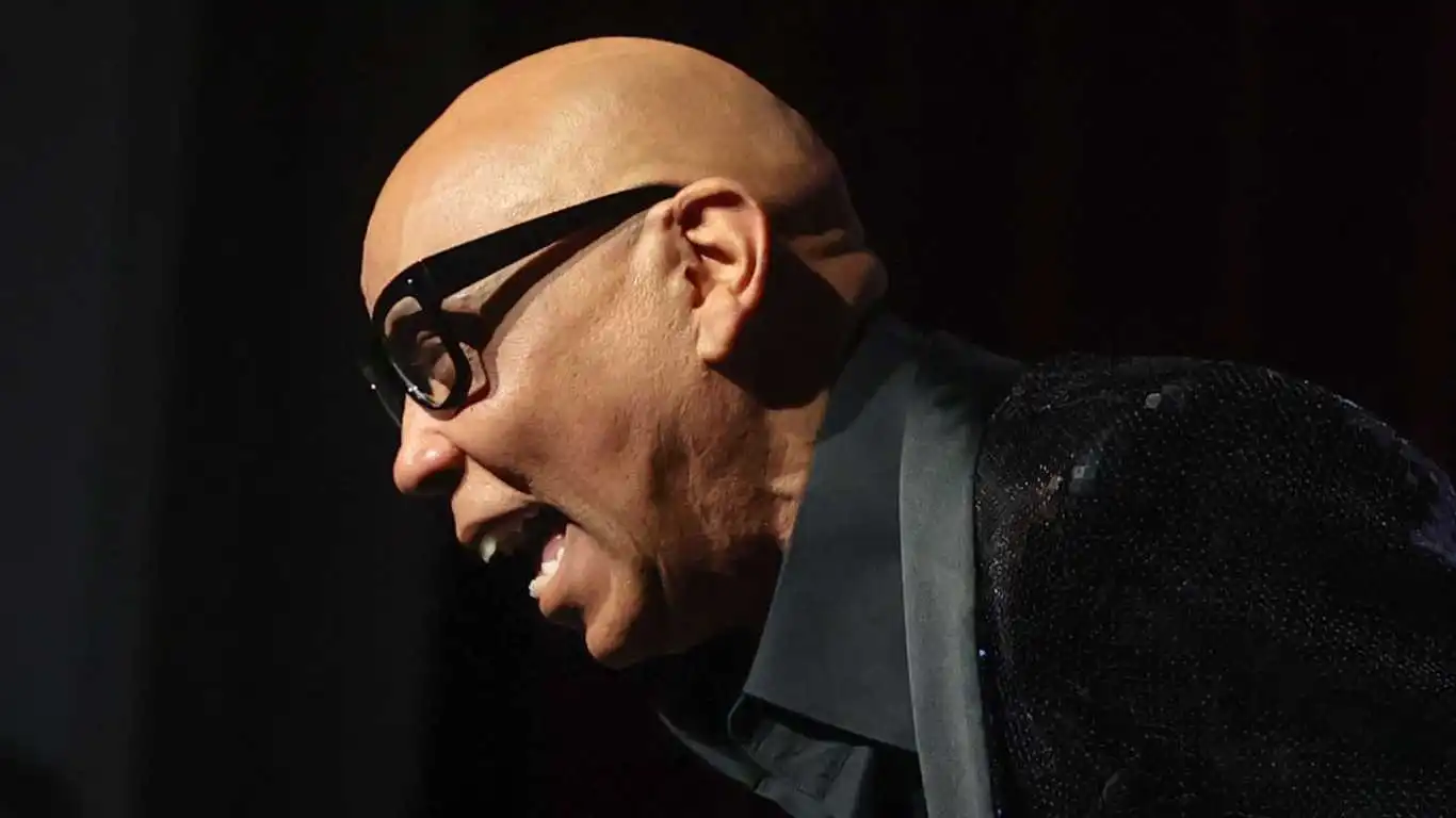 Rupaul laughs while speaking to a large audience to discuss his memoir