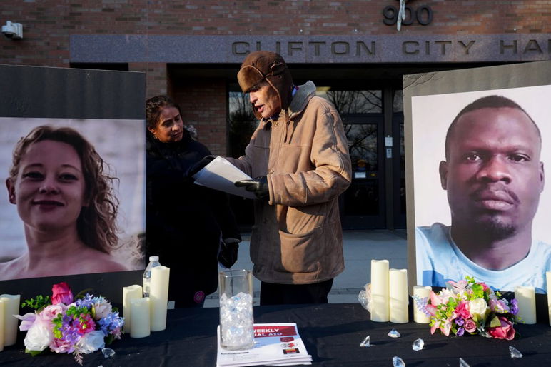 Tejal Desai, de Clifton y Eric Lerner, de Warren, hablan antes del inicio de una vigilia el domingo 11 de enero de 2026 en el Ayuntamiento de Clifton. Se muestran entre una foto de Renee Nicole Good y Jean Wilson Brutus. Good fue asesinado después de recibir un disparo de ICE en Minneapolis a principios de este mes, mientras que Brutus murió mientras estaba bajo custodia de ICE el mes pasado aquí en Nueva Jersey.

