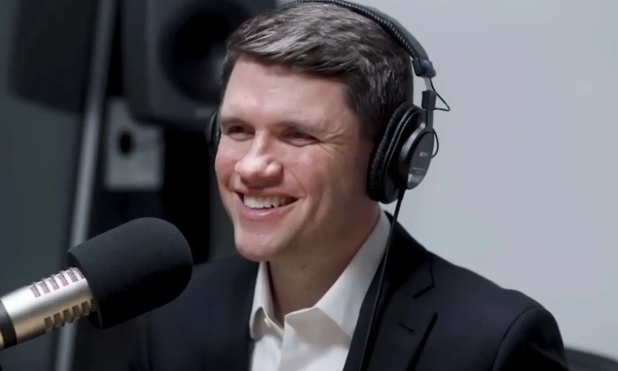 James Talarico, pictured in a recording booth with headphones on.