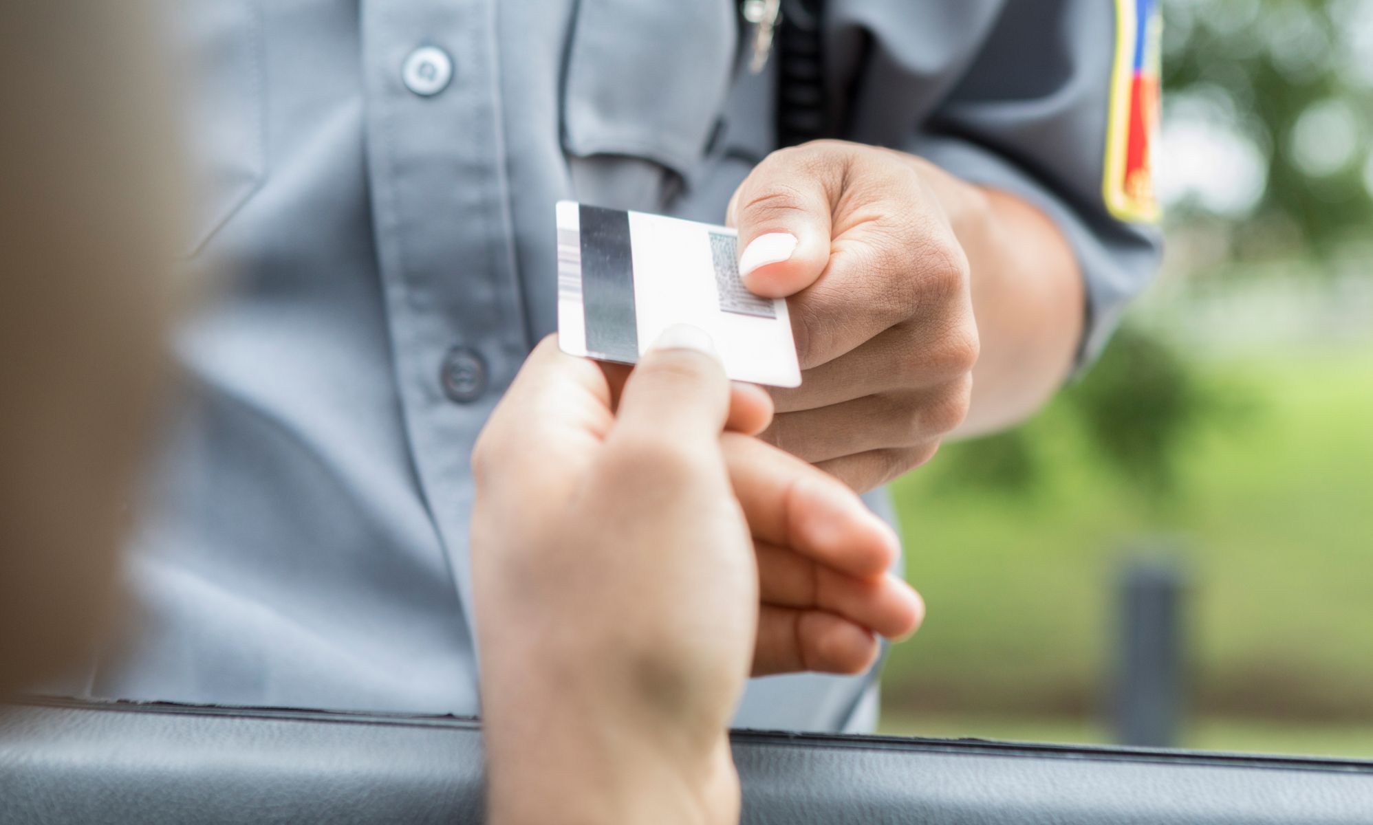 A person handing an officer their license.