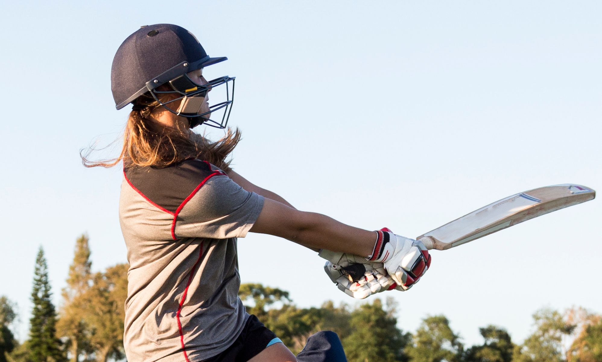 Someone swinging a cricket bat.