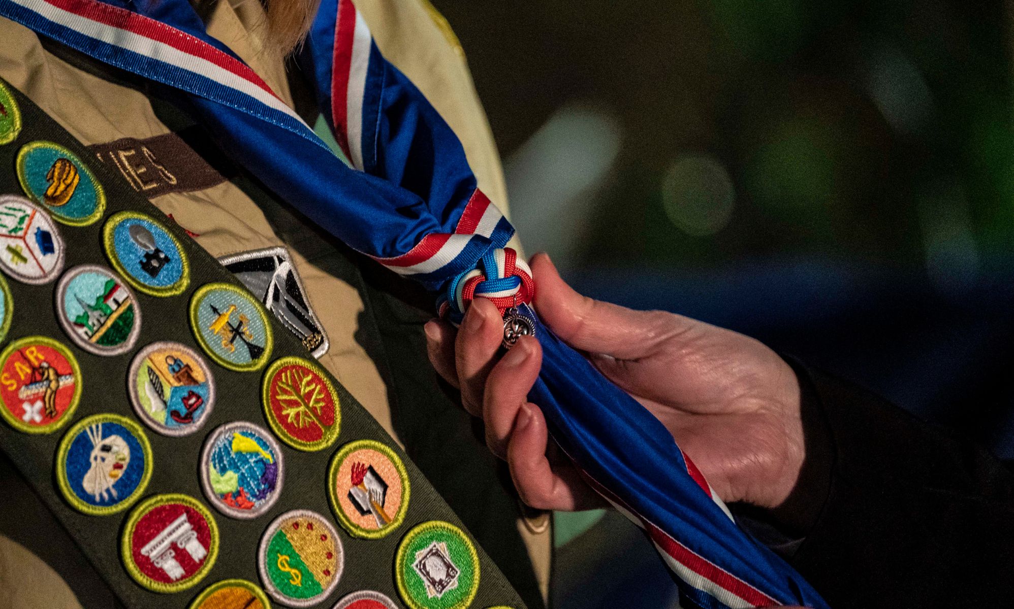 A person holds the tie of a Boy Scout.