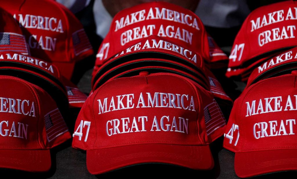 "Make America Great Again" hats sit on a table during a campaign rally for former US President and Republican presidential candidate Donald Trump.