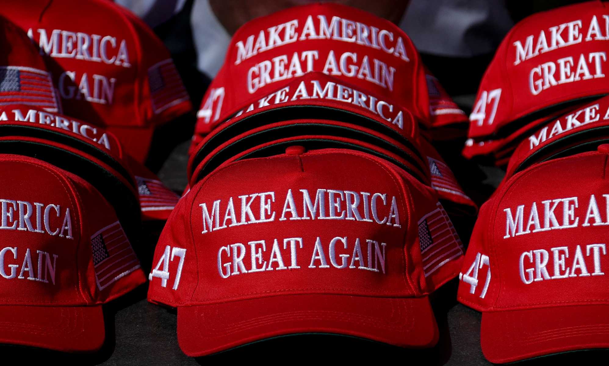 "Make America Great Again" hats sit on a table during a campaign rally for former US President and Republican presidential candidate Donald Trump.