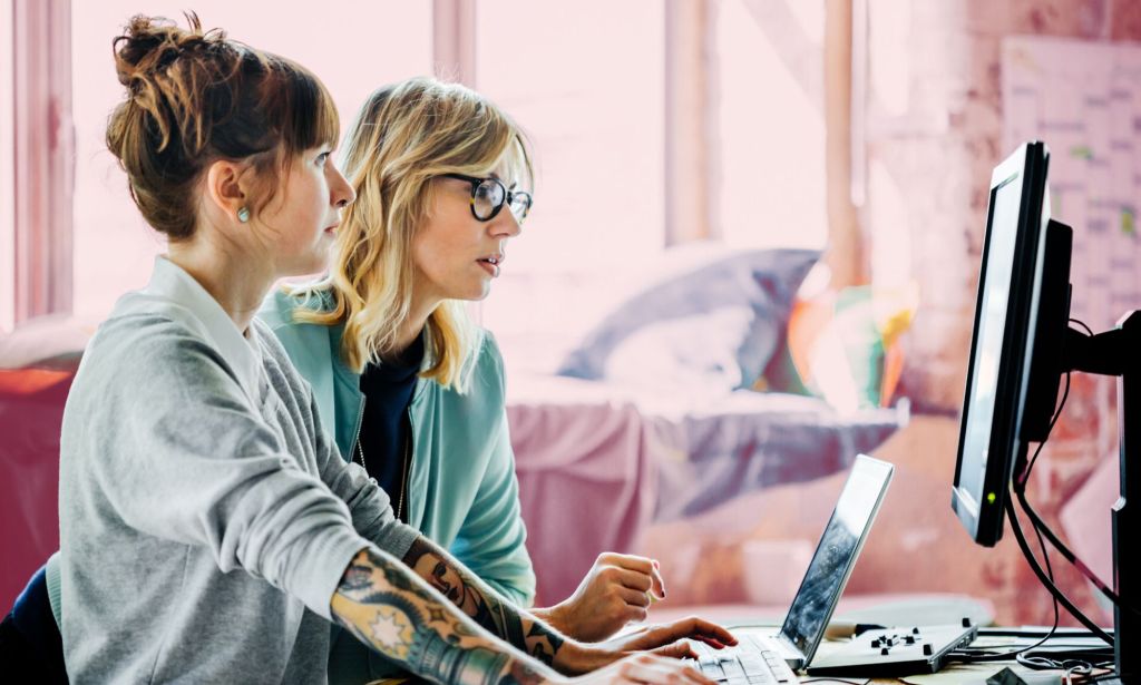 Esta es una imagen de dos mujeres trabajando frente a una computadora.