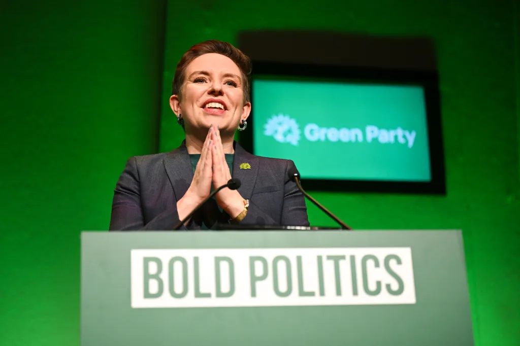 Carla Denyer MP de pie en el podio del Partido Verde