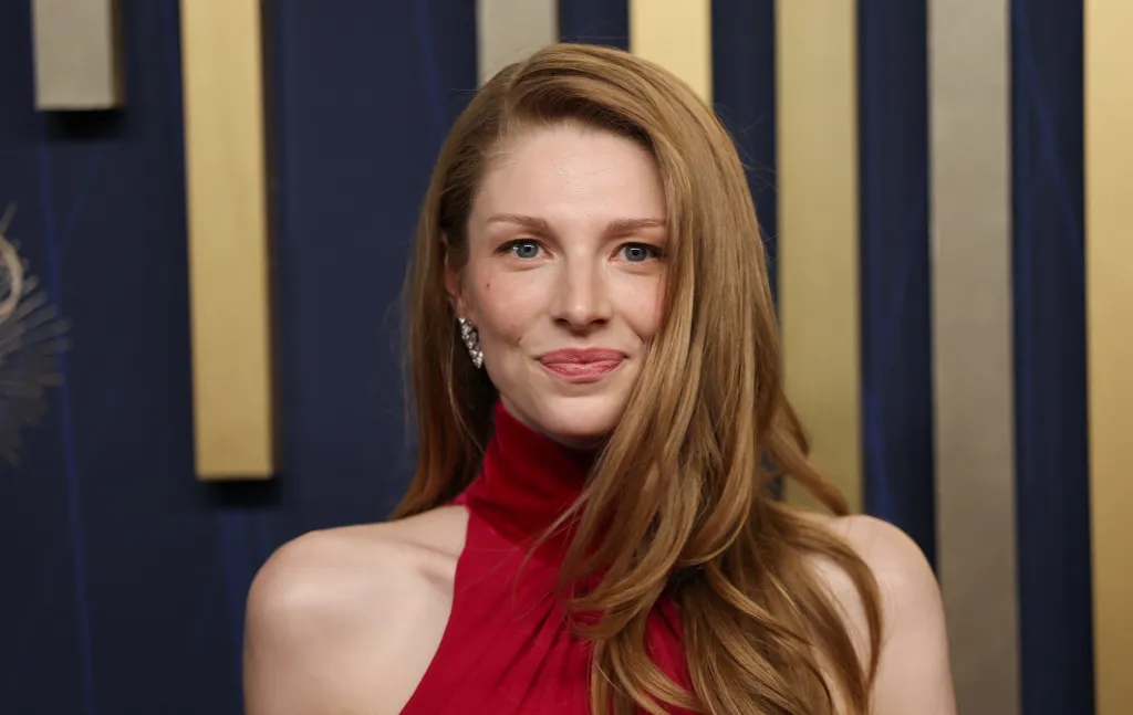 Hunter Schafer con su cabello rubio suelto y un vestido rojo de cuello alto