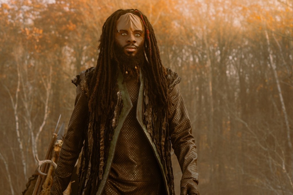 El actor Karim Diané como Jay-Den Kraag en Star Trek: Starfleet Academy. Tiene largas rastas de color marrón oscuro y un abrigo de malla de camuflaje.