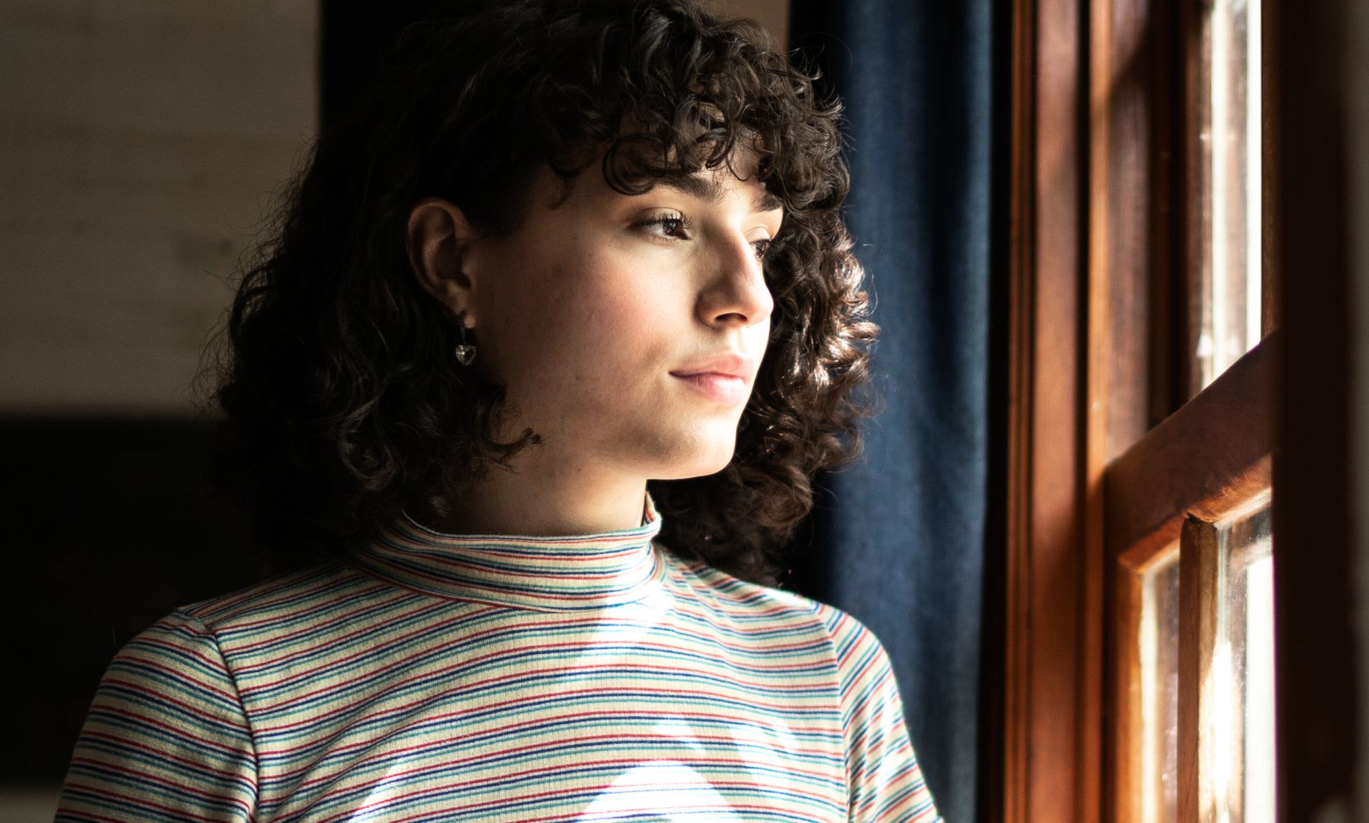 A trans person looking at the window.