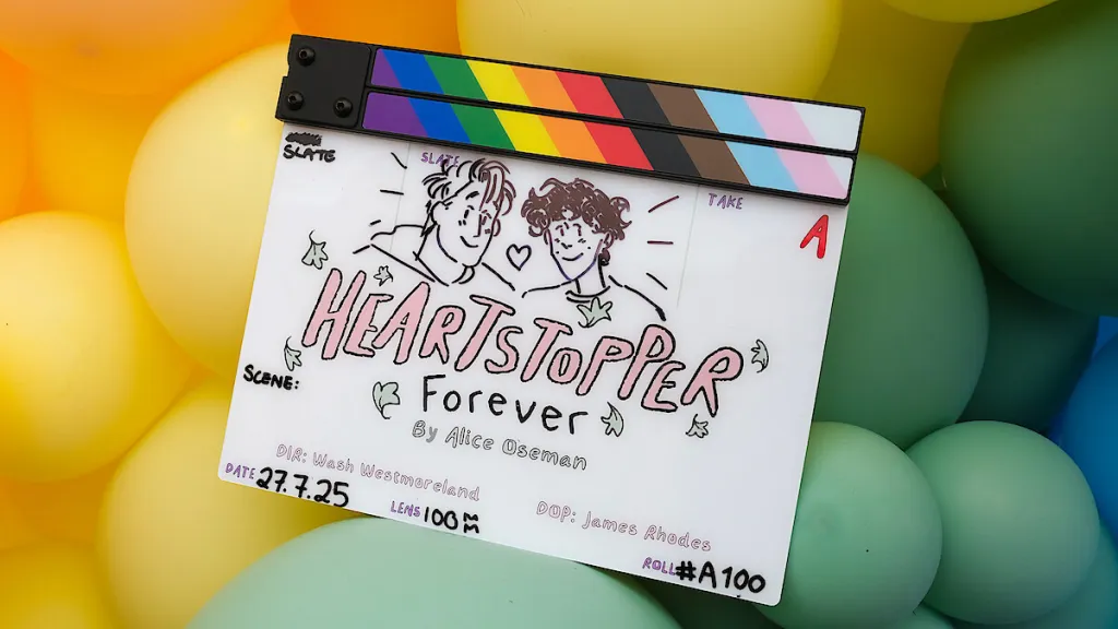 Claqueta de película de Heartstopper Forever de Alice Oseman encima de globos arcoiris.