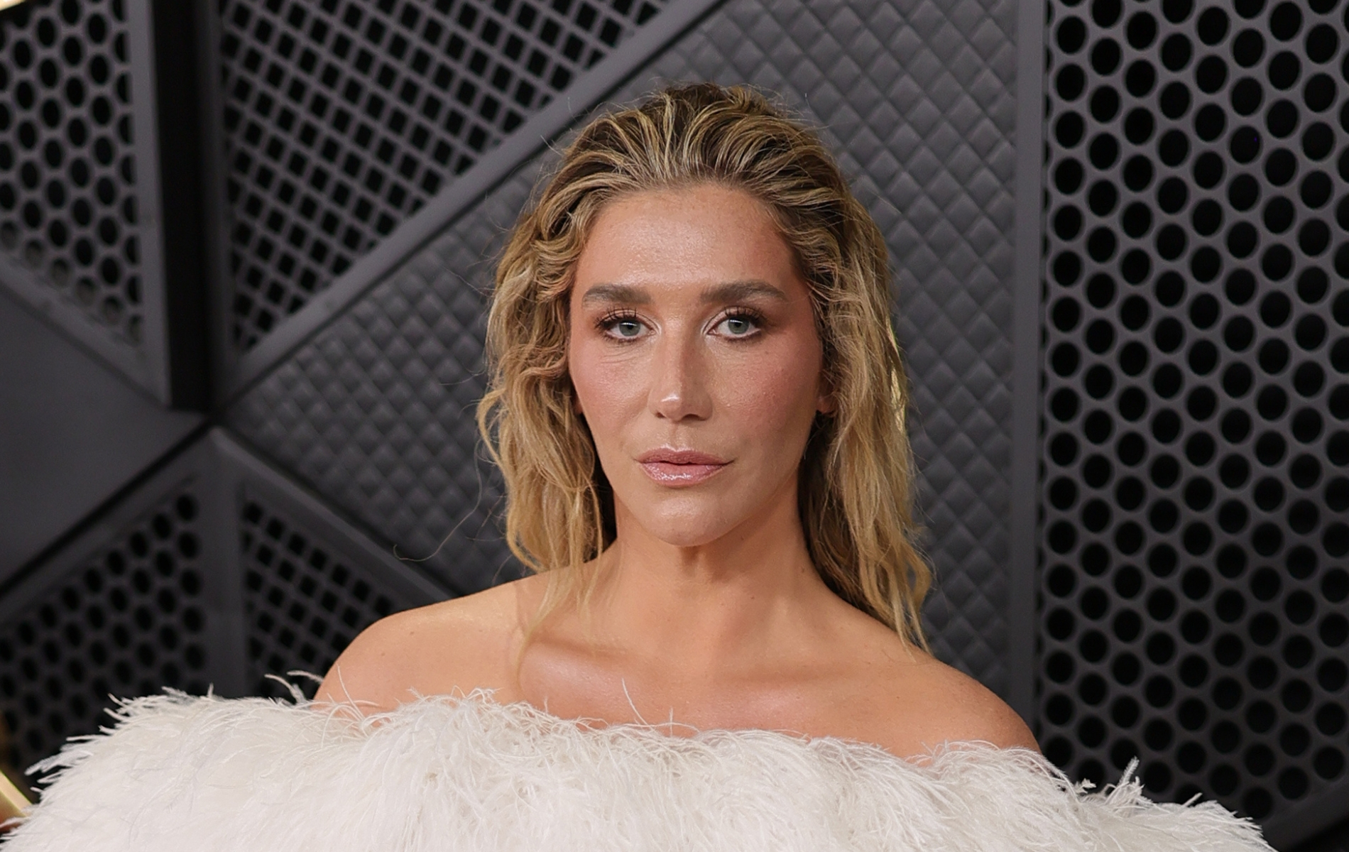 Kesha attends the 68th GRAMMY Awards, wearing a strapless feathered white dress.