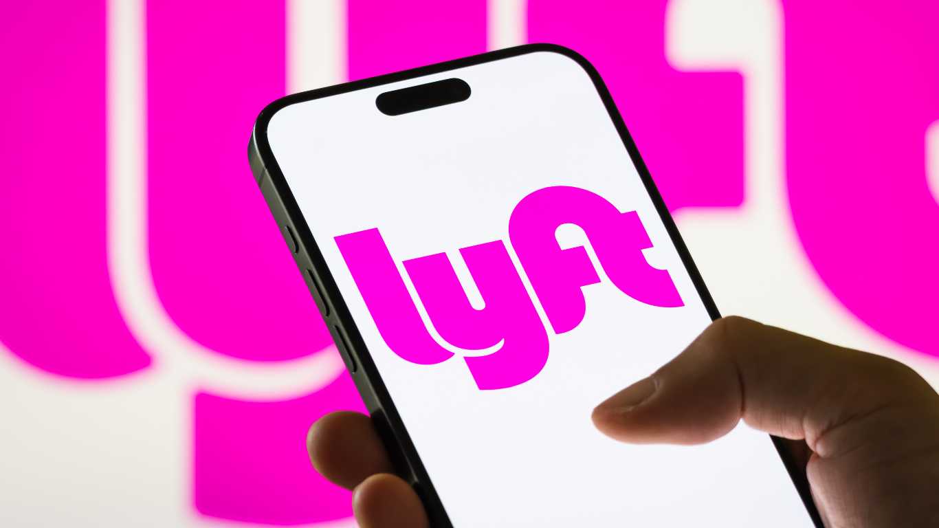 In this photo illustration, a smartphone displays the logo of Lyft Inc. (NASDAQ: LYFT), a major American ride-sharing company, with a blurred version of the company