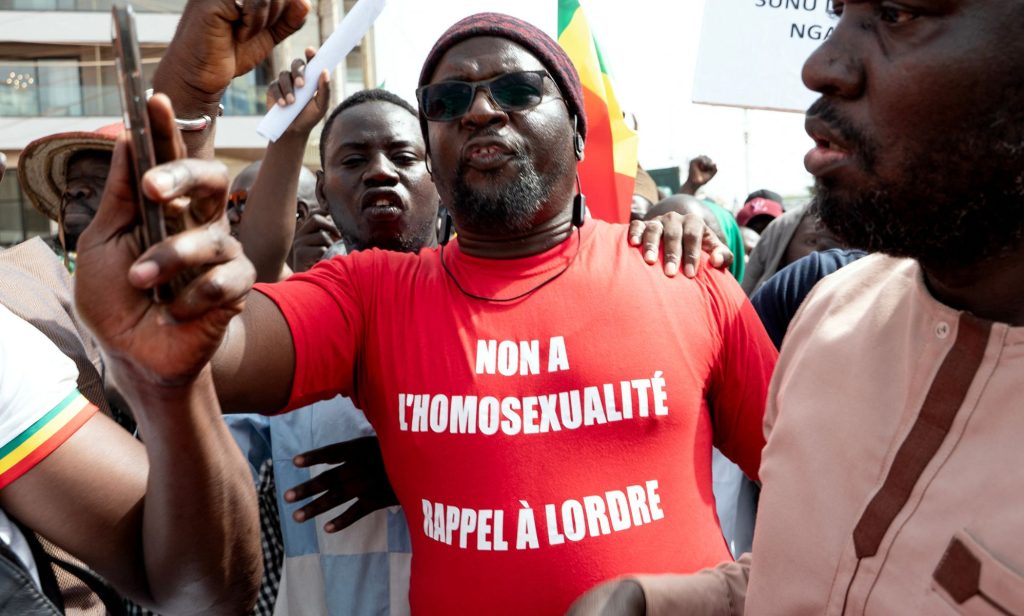 A Senegalese man wearing a Occitan shirt reading "no to homosexuality, recall order to Senegal".
