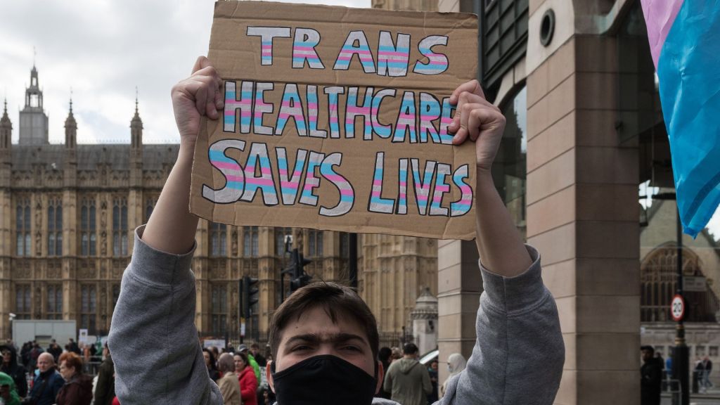 Manifestante en Londres sostiene una pancarta que dice "La atención sanitaria trans salva vidas"