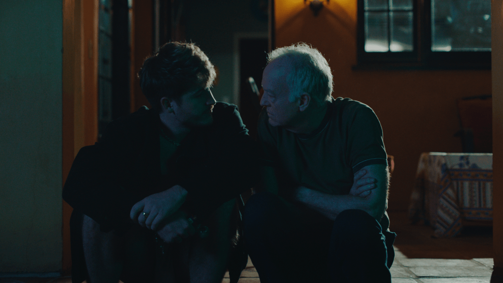 Aaron y Hank se sentaron afuera en la oscuridad, inclinándose el uno hacia el otro.