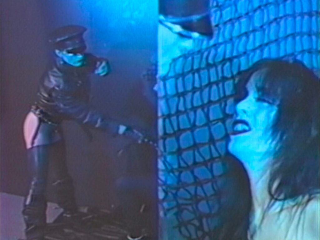 Mixtape lésbico pixelado: Wicked Times de Azian Nurudin todavía: una persona con un látigo en el fondo con una mujer en primer plano.