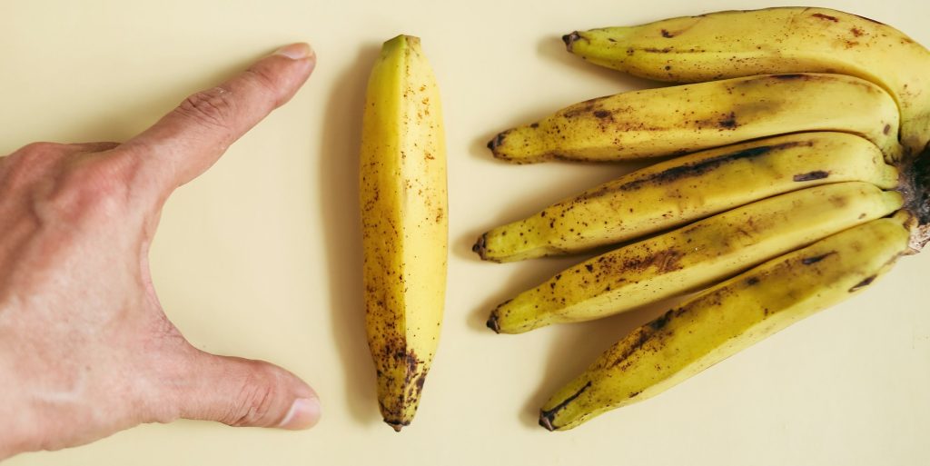 man measuring a banana