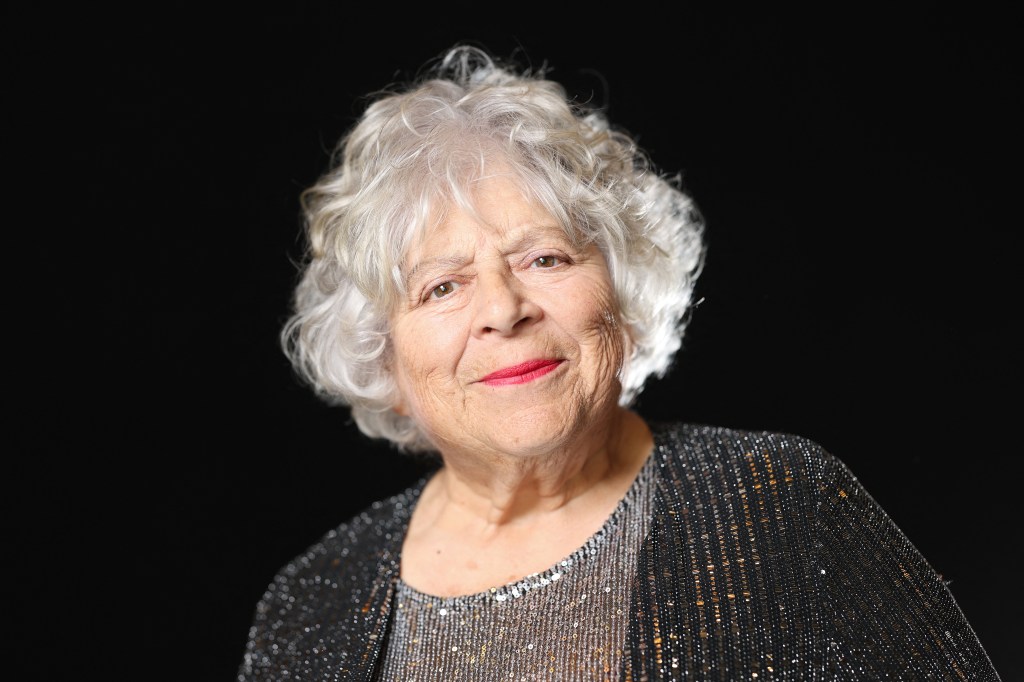 Miriam Margolyes posa durante una sesión de fotos previa a la 98ª edición de los nominados a los Oscar. Lleva un top gris de lentejuelas y un cárdigan brillante gris oscuro.