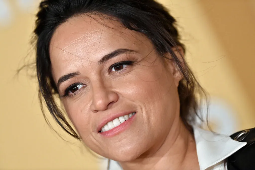 Michelle Rodríguez con una camisa blanca de cuello y el pelo recogido.