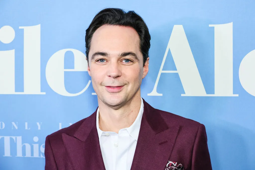 La estrella de The Big Bang Theory, Jim Parsons, con un traje burdeos y una camisa blanca.