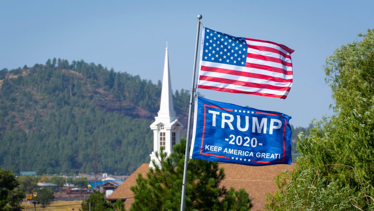 Williams, AZ/USA - 19/09/2020: Bandera estadounidense y bandera de Trump 2020 con campanario de la iglesia