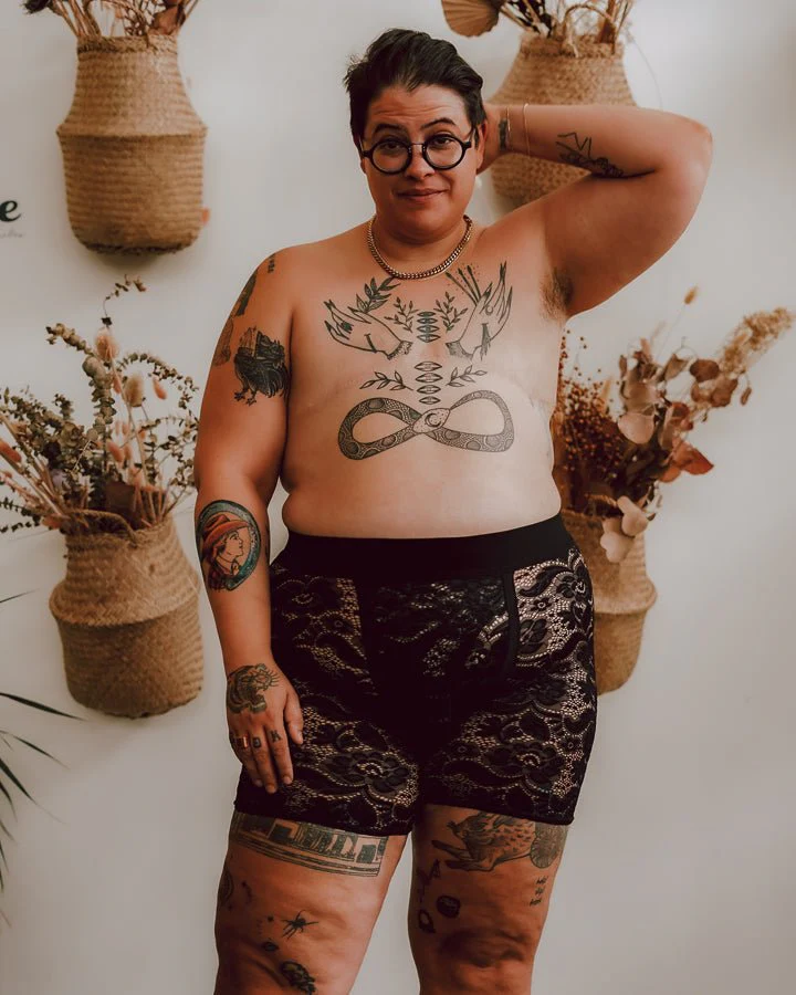 una persona trans con tatuajes usa un par de ropa interior de encaje de género neutro de cantiqLA