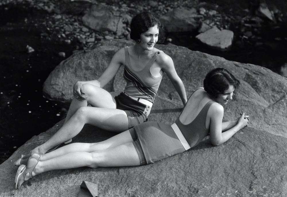 Two women relaxing on a rock in the 1920s