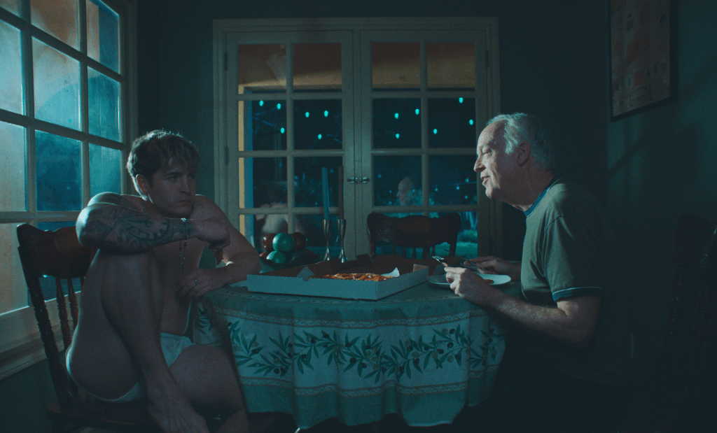 Aaron y Hank estaban sentados en la oscuridad con una pizza para llevar en la mesa.