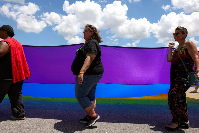 La gente porta una gran bandera del arco iris mientras marcha en el desfile durante el quinto festival anual del Orgullo de la Costa del Tesoro el 25 de abril de 2026, en el recinto ferial del condado de St. Lucie. El evento fue organizado por el Santuario de la Costa del Tesoro.