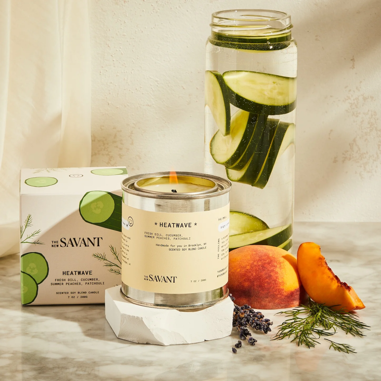 La vela Heatwave VERDE / HERBÁCEA de The New Savant's frente a los ingredientes que componen su aroma