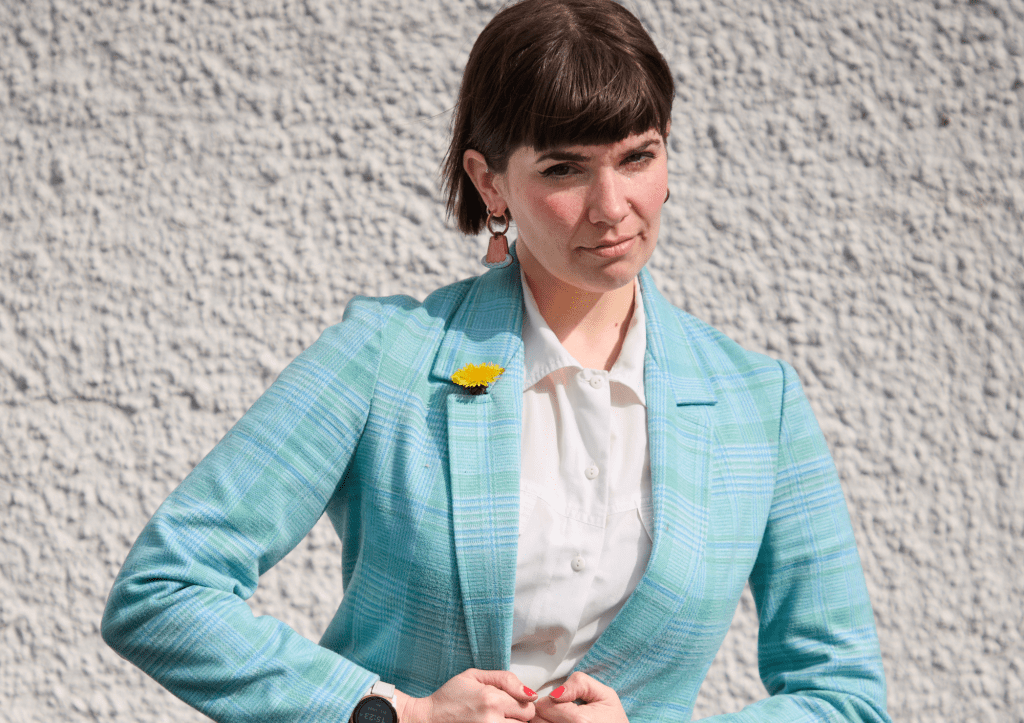 Kate Hammer: comediante aprobada por el gobierno. Kate abotonándose un traje azul.