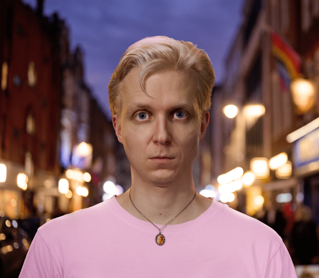 Linus Karp fue golpeado con un paraguas: un hombre con una camiseta rosa en una calle mirando a la cámara.