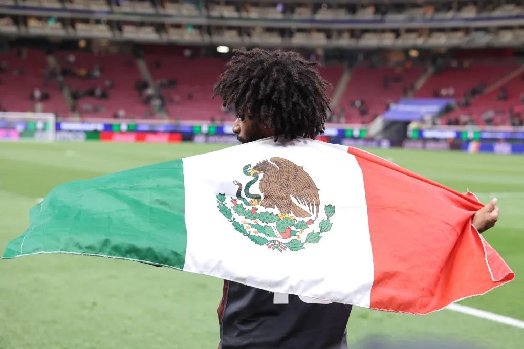 Joseph Athalé con la bandera de México tras la derrota del equipo en el partido del torneo Eliminatorias Clasificatorias para la Copa Mundial de la FIFA 2026