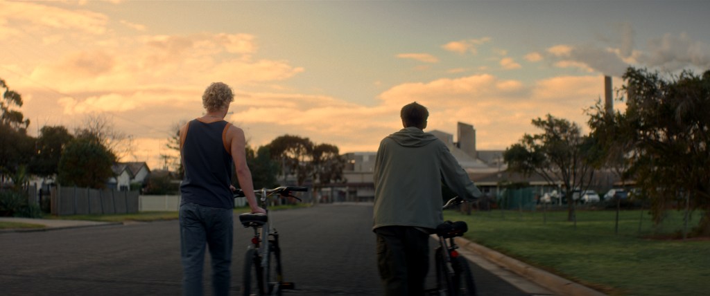 Levítico todavía: dos niños empujando bicicletas al atardecer