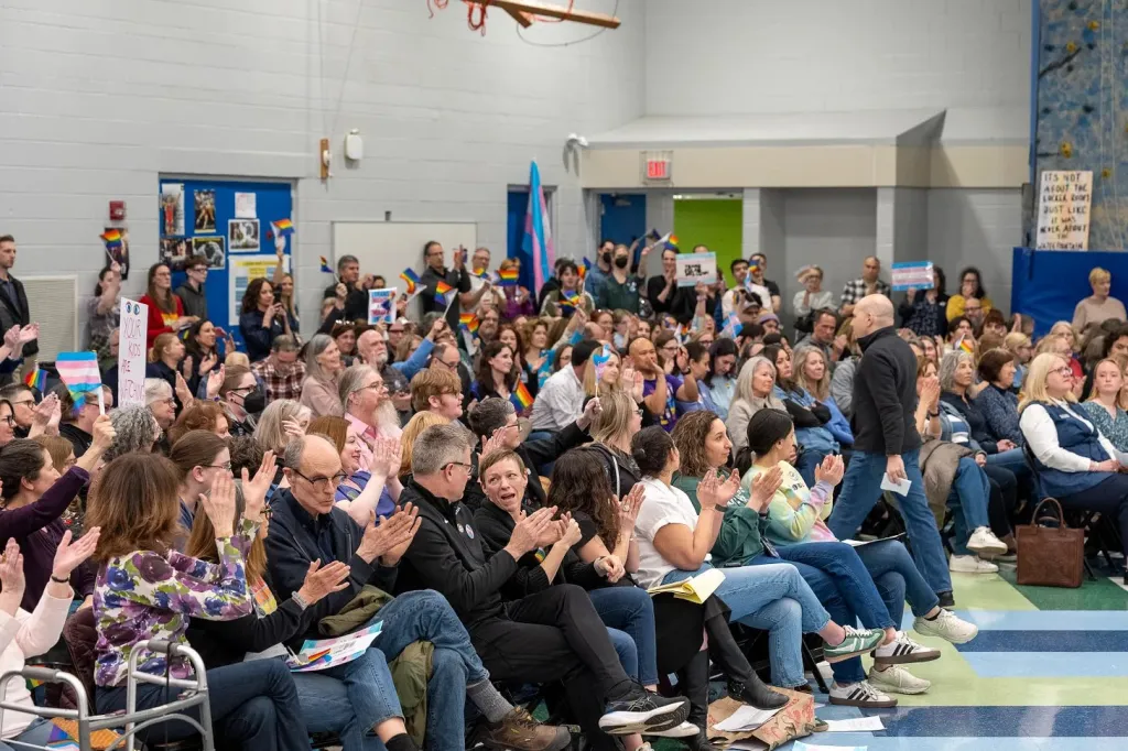 Cientos de miembros de la comunidad y partidarios de los derechos trans aplauden y animan durante una reunión de la junta directiva del Distrito 109 de Deerfield en la escuela secundaria Caruso en Deerfield, Illinois, el 10 de abril de 2025. Foto de Tyler Pasciak LaRiviere para el Chicago Sun-Times.