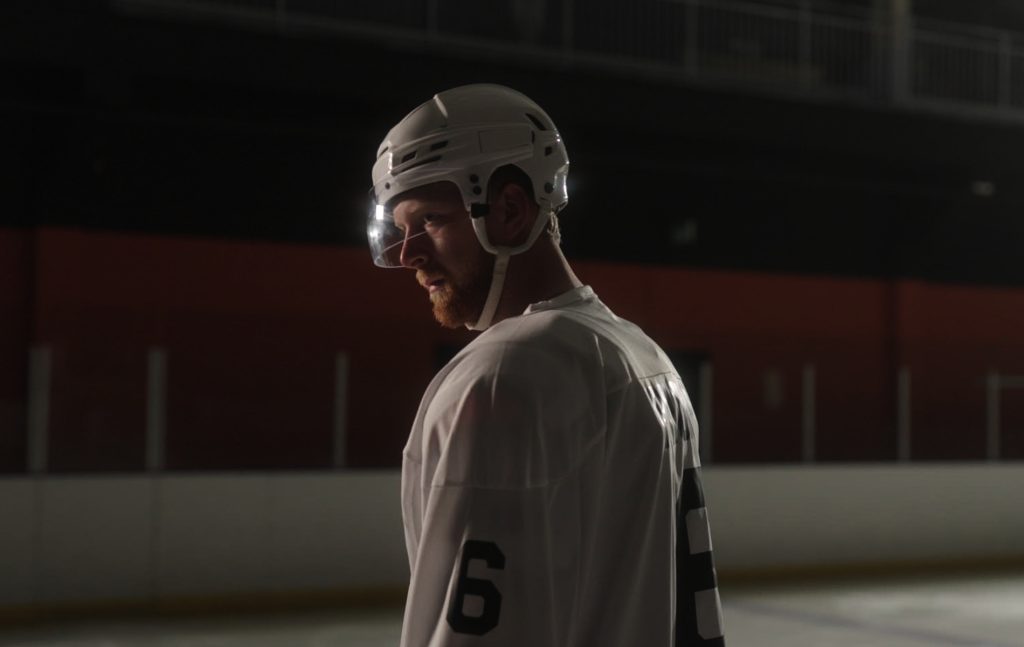 Luke Prokop in ice hockey gear in a dim rink