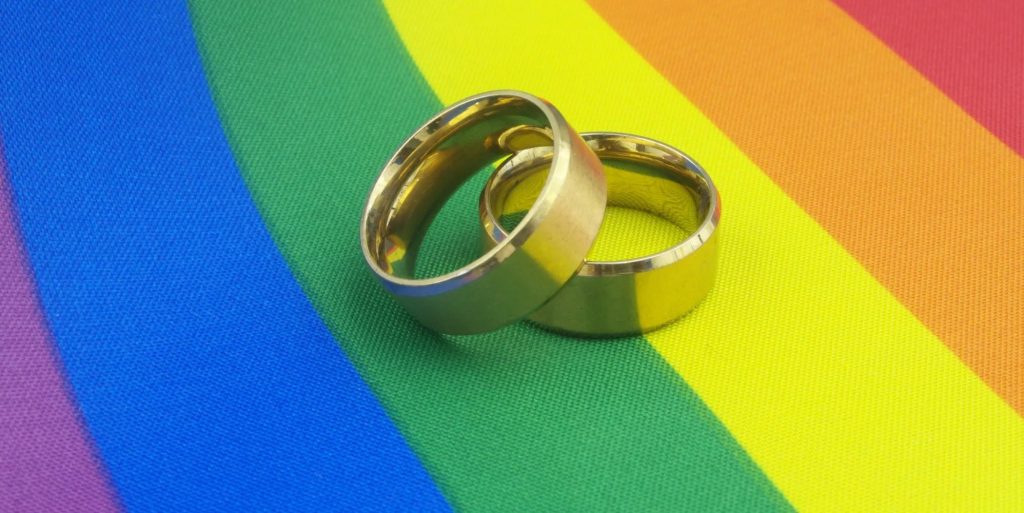 wedding rings on pride flag