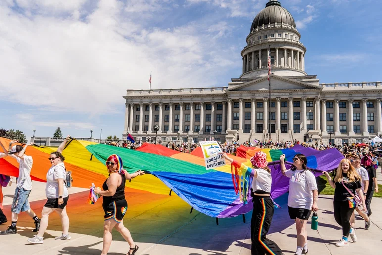 Salt Lake City, Utah EE.UU. 1 de junio de 2024: Multitud caminando Bandera del Orgullo Arco Iris Abajo Capitol Hill SLC Mes del Orgullo