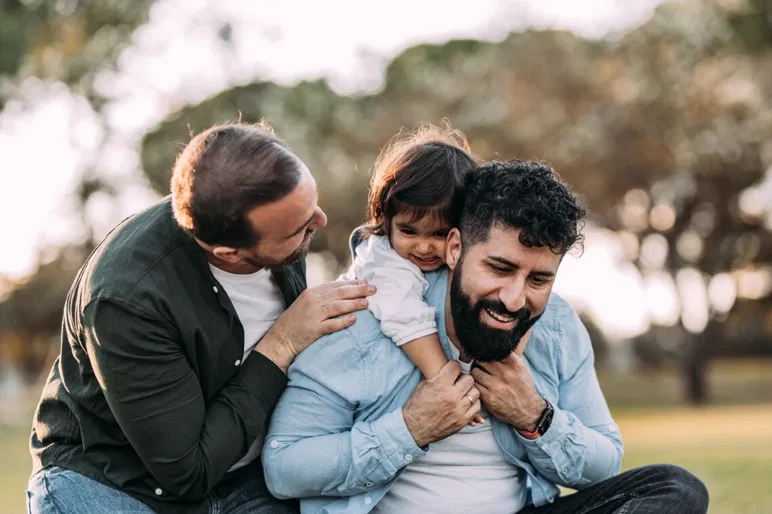 Dos hombres homosexuales con un bebé concebido mediante subrogación o adopción.