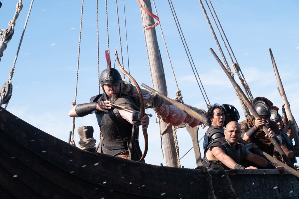 Fotograma de La Odisea: Matt Damon disparando un arco y una flecha desde un barco
