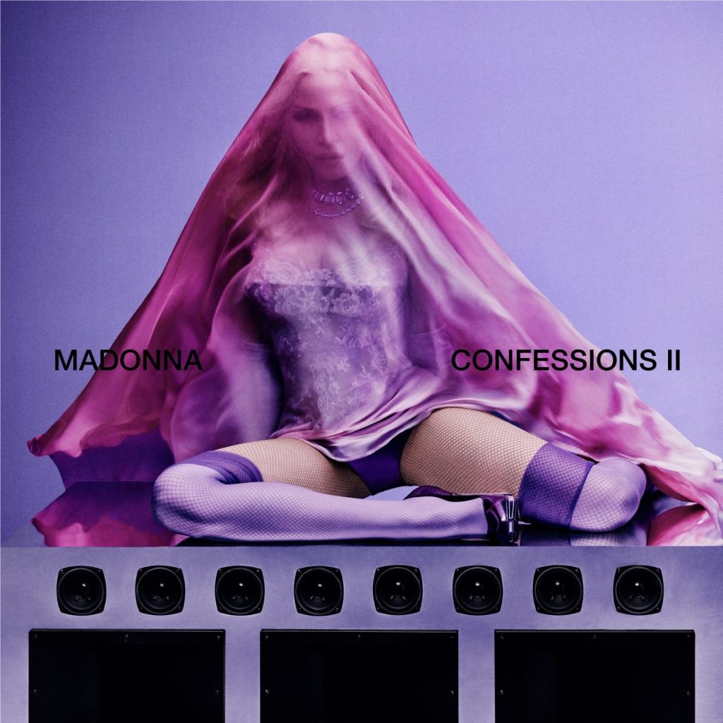 Confesiones de Madonna II ya está disponible. La carátula del álbum de Madonna sentada encima de un altavoz con medias moradas y un corsé cubierto con un pañuelo de seda rosa transparente.