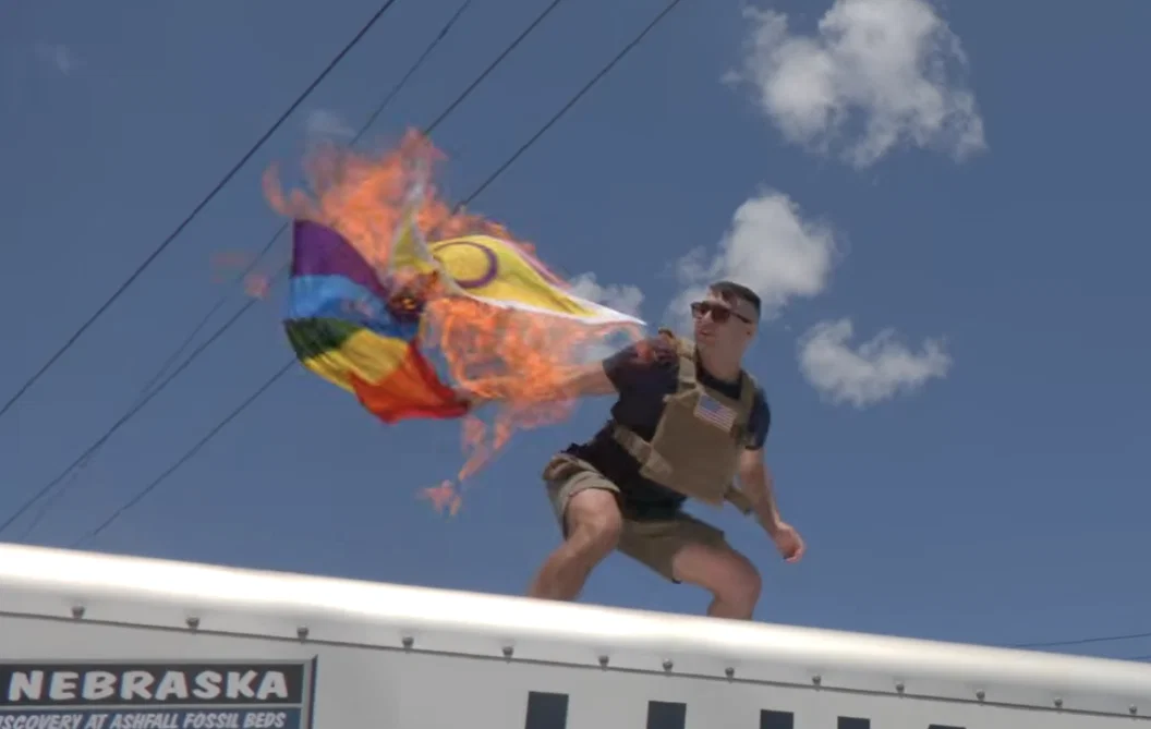 El candidato republicano racista y antisemita, Jake Lang, prende fuego a una bandera del Orgullo progresista frente a una instalación de ICE en Newark, Nueva Jersey, ayer por la tarde.