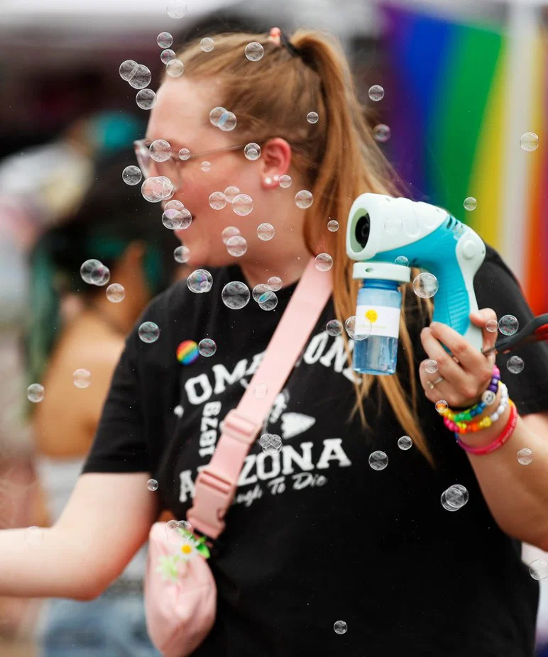 Sheri Gómez de Copper Cactus Therapy sopla burbujas frente a su stand. El sábado se celebró el festival LubbockPRIDE para que la comunidad LGBTQ+ fomente un sentido de comunidad.