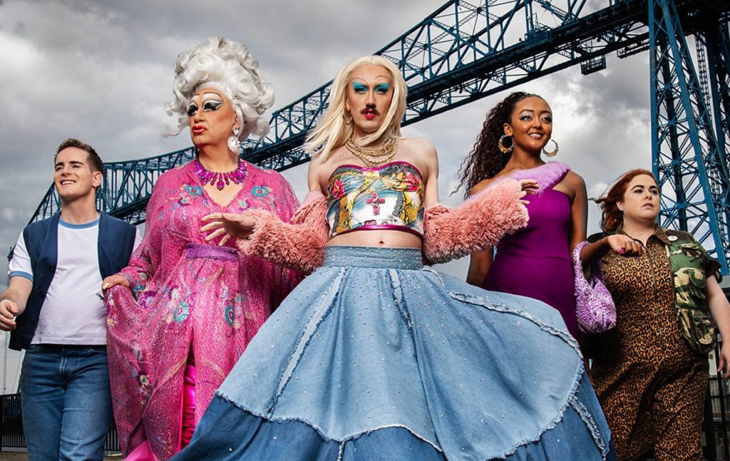 Smoggie Queens still, five individuals walking against a grey cloudy sky